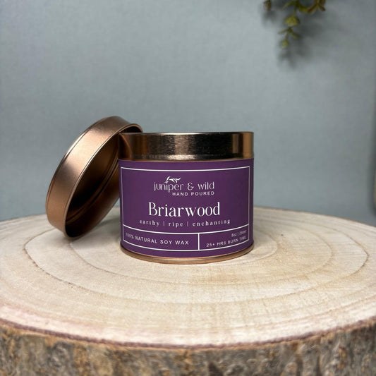 Candle jar with purple label on a wooden surface