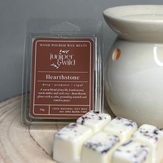 Hand poured wax melts packaging with 'juniper & wild' branding on a wooden surface.