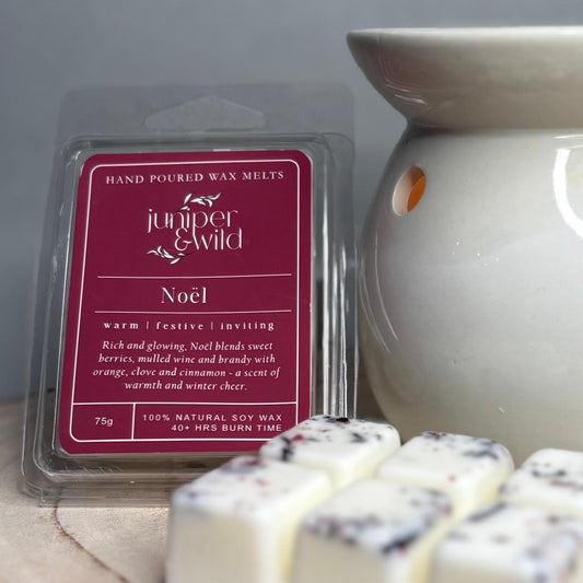 Hand poured wax melts packaging with 'juniper & wild' branding next to a wax melt and diffuser.
